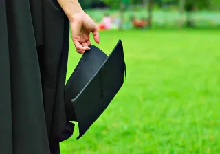 image of graduate standing with cap